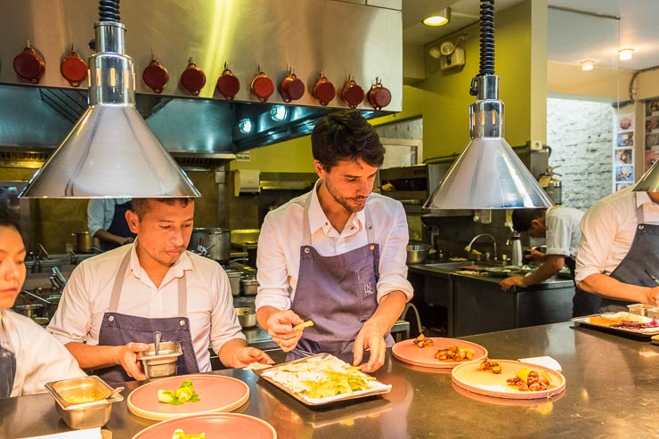 Central restaurant in Lima, Peru. Chefs are plating in series. In the forefront, Virgilio, the owner of Central, participating of the plating process