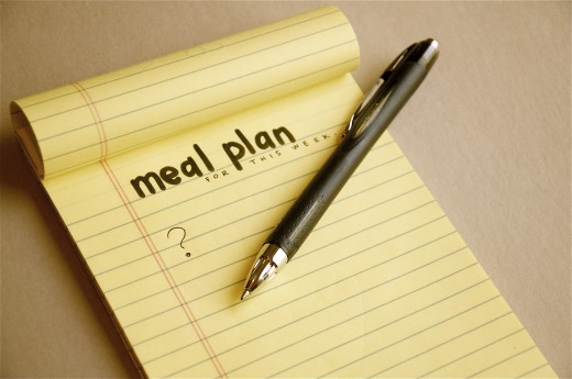 An open notebook. In one page, it reads meal plan for this week. Then a question mark. There's a pen on the notebook. 